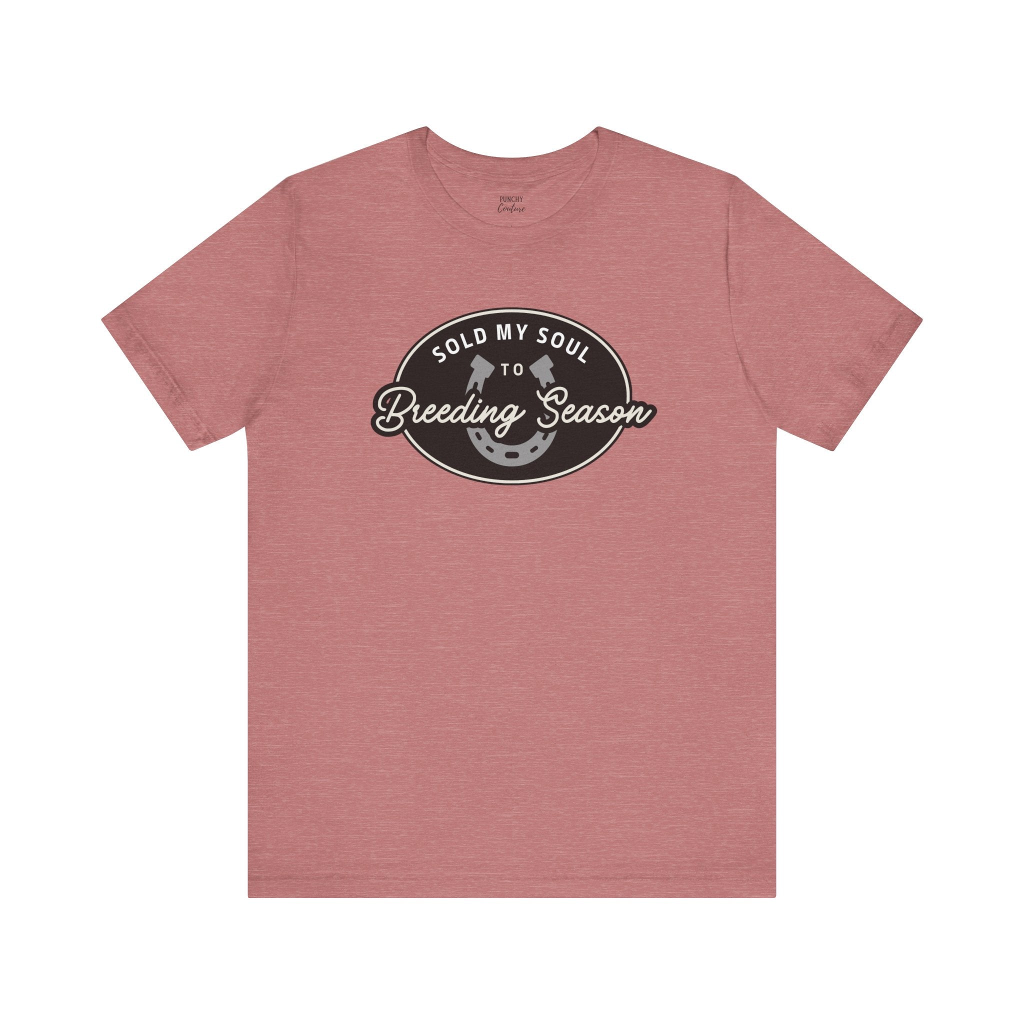 Pink t-shirt with black oval emblem featuring white text “SOLD MY SOUL TO Breeding Season” and horseshoe graphic; playful Western tee with ranch-ready attitude.