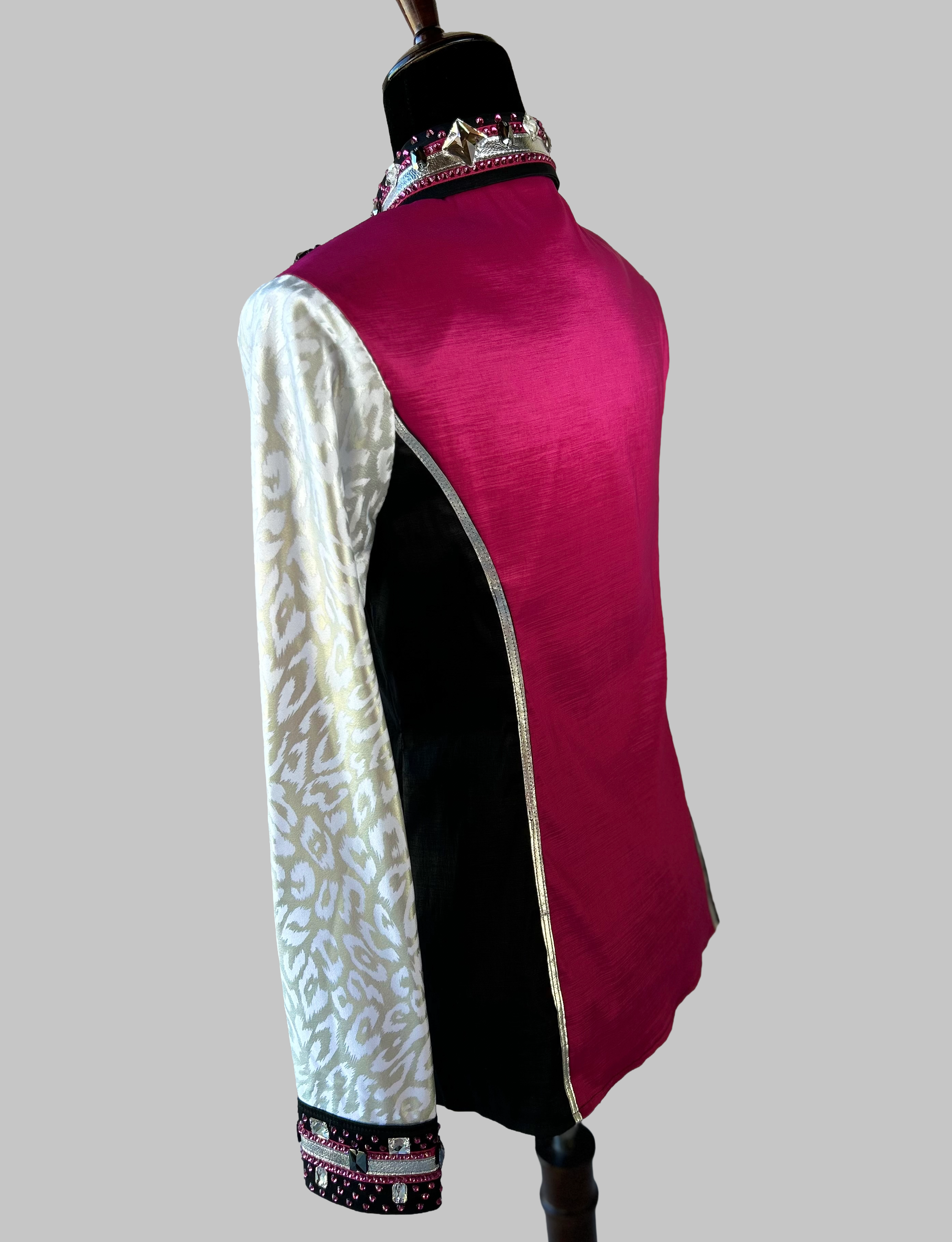 Back view of Western-style performance shirt in magenta, black, and silver with ornate rhinestones, studs, and beaded accents; dramatic show-day design featuring jacquard textures, barbed embellishments, and couture-level craftsmanship.