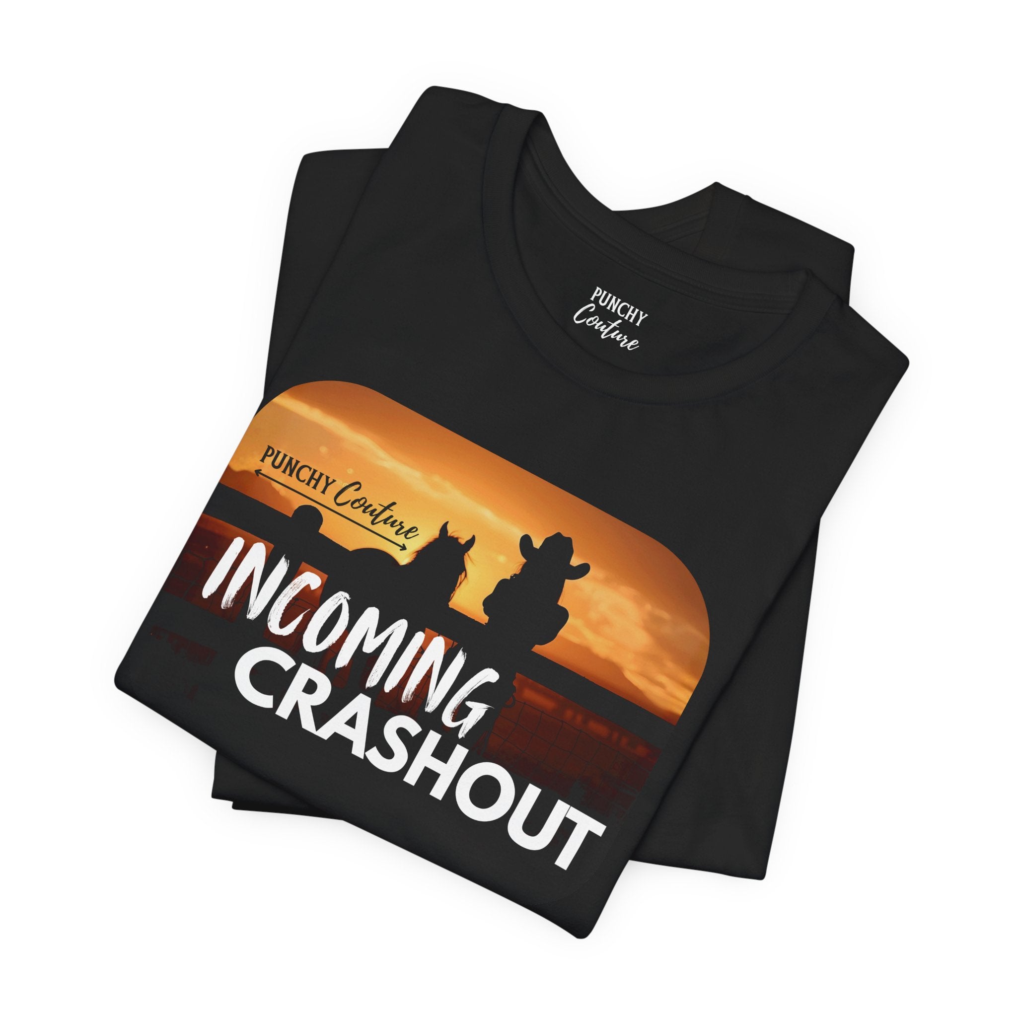 Black t-shirt with sunset graphic featuring silhouettes of two seated figures, one in a cowboy hat, and bold white text reading "INCOMING CRASHOUT" with "PUNCHY Couture" above; Western-themed tee with relaxed, mythic energy